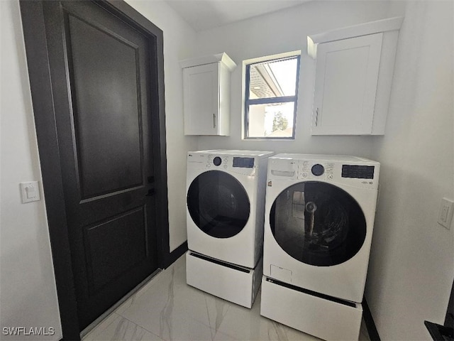 washroom with cabinet space, marble finish floor, and washing machine and clothes dryer