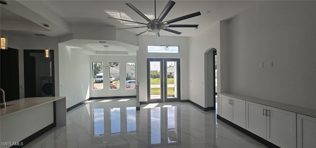 foyer with washer / dryer, baseboards, marble finish floor, and arched walkways