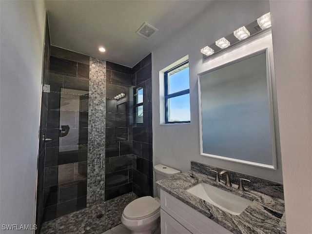 full bathroom featuring vanity, toilet, visible vents, and a stall shower