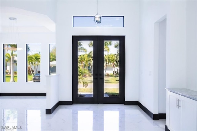 doorway to outside featuring baseboards, french doors, plenty of natural light, and marble finish floor