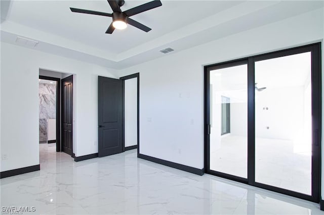 unfurnished room featuring visible vents, marble finish floor, baseboards, and a tray ceiling