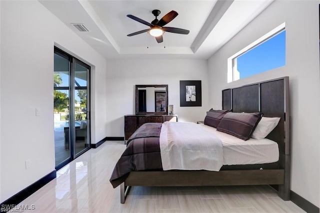 bedroom featuring visible vents, a ceiling fan, access to outside, a tray ceiling, and baseboards