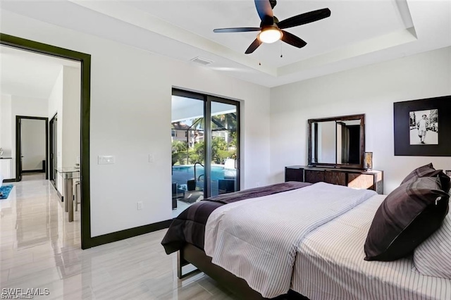 bedroom featuring baseboards, a raised ceiling, access to exterior, and a ceiling fan