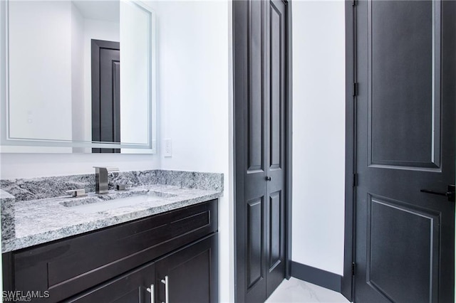 bathroom featuring vanity, baseboards, and marble finish floor