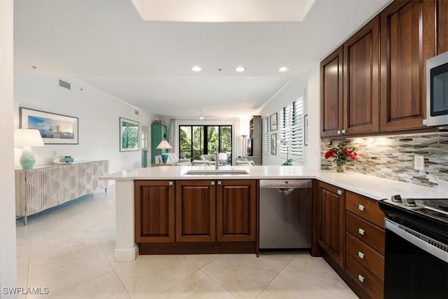 kitchen with light countertops, visible vents, appliances with stainless steel finishes, a sink, and a peninsula