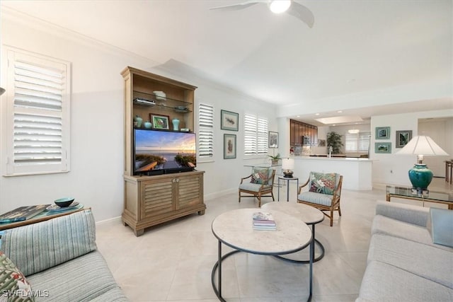 living area featuring light tile patterned floors, baseboards, and crown molding