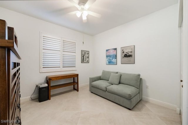 sitting room with a ceiling fan and baseboards