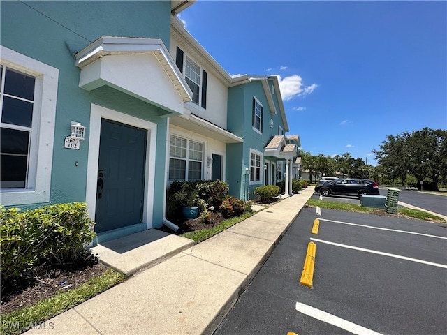 view of property exterior featuring uncovered parking and stucco siding