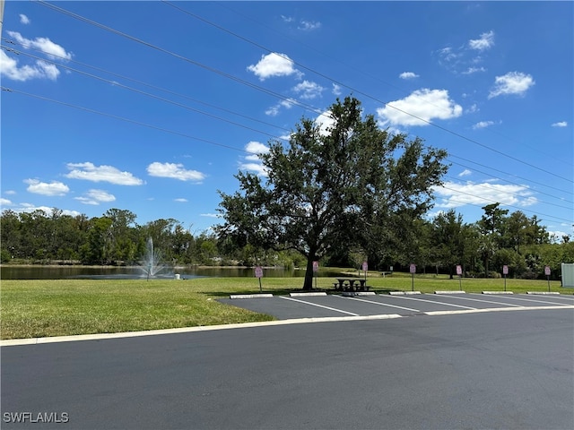 uncovered parking lot featuring a water view