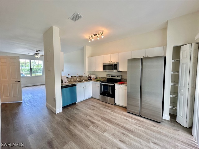 kitchen with light wood finished floors, appliances with stainless steel finishes, visible vents, and white cabinetry