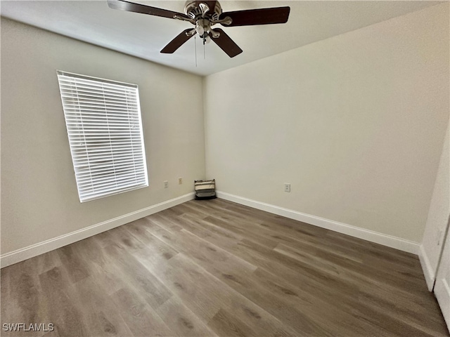 empty room featuring ceiling fan, baseboards, and wood finished floors