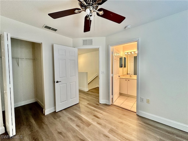 unfurnished bedroom featuring light wood finished floors, visible vents, and a closet