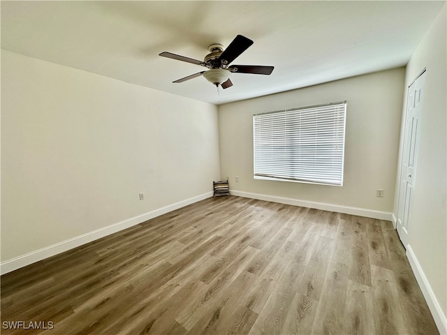 spare room with a ceiling fan, baseboards, and wood finished floors