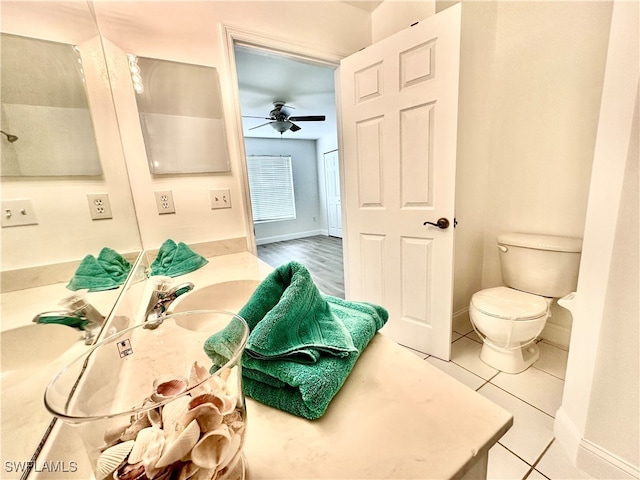 bathroom featuring toilet, ceiling fan, baseboards, and tile patterned flooring