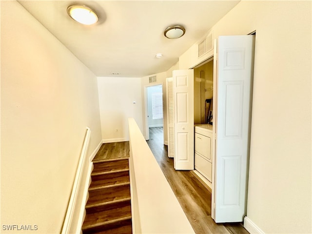 stairway with washer / dryer, visible vents, baseboards, and wood finished floors