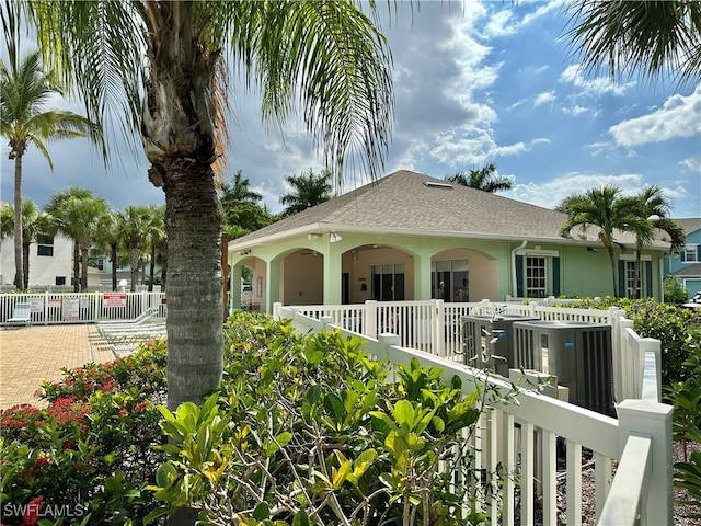 exterior space featuring a fenced front yard, a gate, a shingled roof, and stucco siding