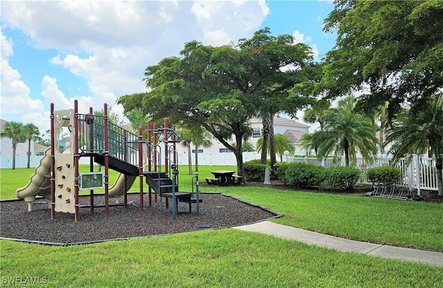 community play area with a yard and fence