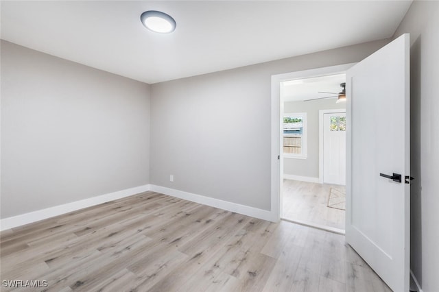 unfurnished room with light wood-style flooring and baseboards