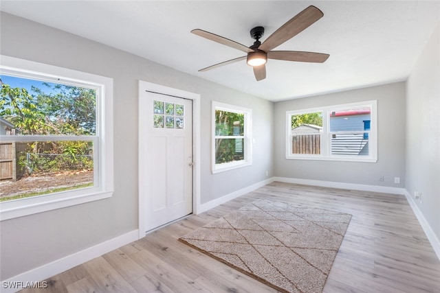 foyer with light wood-style floors, ceiling fan, and baseboards