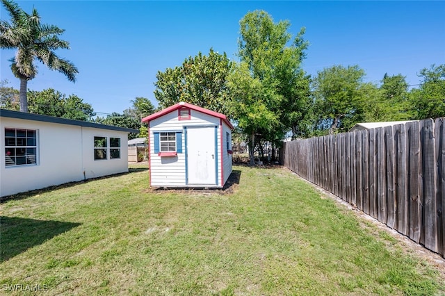 view of yard with a storage unit, an outdoor structure, and a fenced backyard