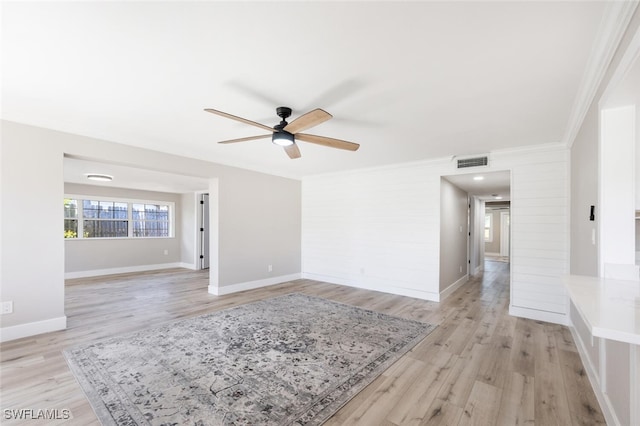 unfurnished room featuring ornamental molding, light wood-style flooring, visible vents, and baseboards