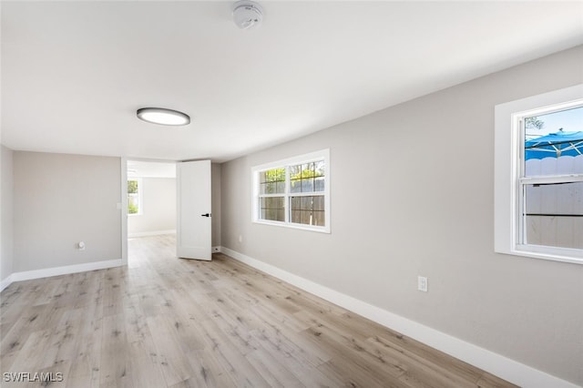 empty room with light wood finished floors and baseboards