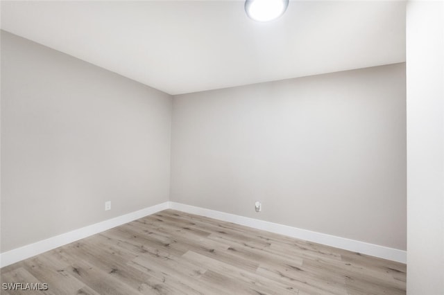 spare room with light wood-style floors and baseboards