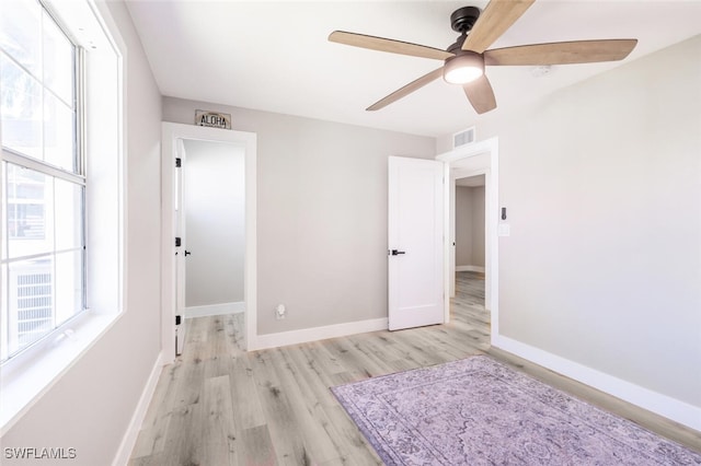 unfurnished bedroom with visible vents, ceiling fan, baseboards, and wood finished floors