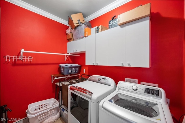 laundry area with cabinet space, washing machine and clothes dryer, and crown molding