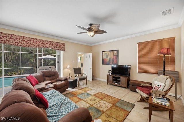 living area with light tile patterned floors, visible vents, a ceiling fan, and crown molding