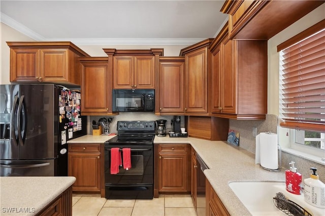 kitchen featuring light tile patterned floors, light countertops, black appliances, and decorative backsplash