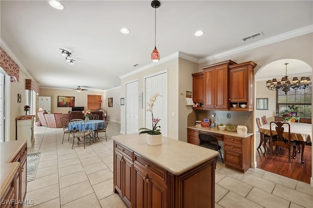 kitchen featuring visible vents, light tile patterned floors, ornamental molding, light countertops, and a chandelier