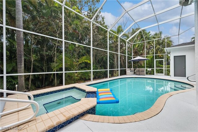 pool featuring a patio, an in ground hot tub, and glass enclosure