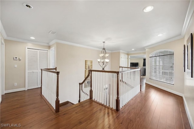 corridor with baseboards, visible vents, a notable chandelier, and an upstairs landing