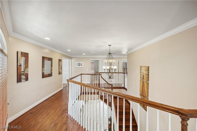 hallway with a notable chandelier, baseboards, recessed lighting, an upstairs landing, and wood finished floors
