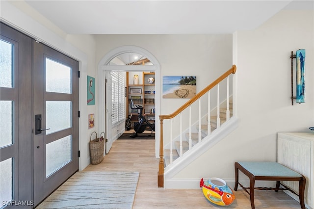 entrance foyer with wood finished floors, french doors, and stairs