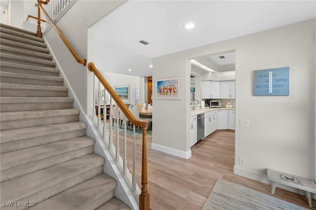 stairway with a toaster, baseboards, visible vents, wood finished floors, and recessed lighting