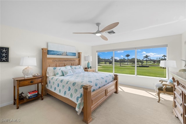 bedroom with light carpet, ceiling fan, visible vents, and baseboards