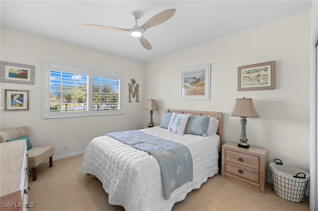 bedroom with light carpet, ceiling fan, and baseboards