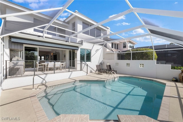 pool featuring glass enclosure and a patio area