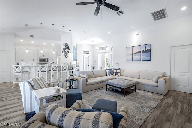 living room featuring recessed lighting, visible vents, and light wood-style flooring