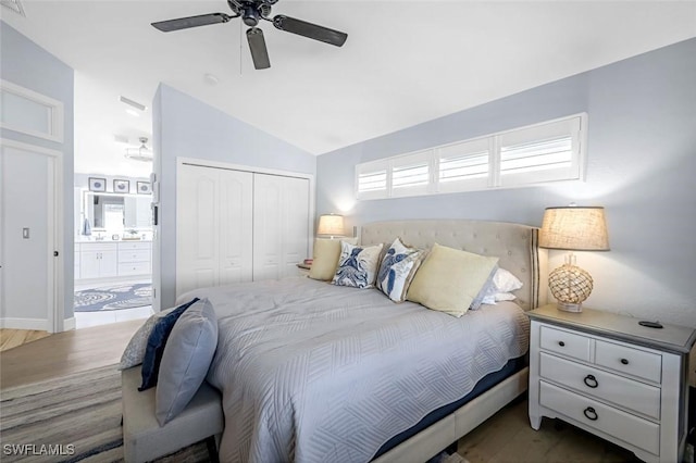 bedroom featuring lofted ceiling, ensuite bath, ceiling fan, and a closet