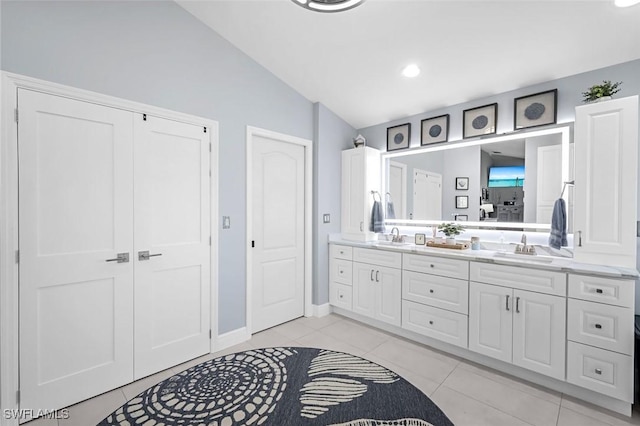 full bath with lofted ceiling, double vanity, a sink, and tile patterned flooring