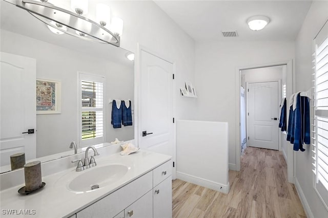 bathroom featuring vanity, wood finished floors, visible vents, and baseboards