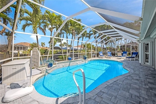 outdoor pool featuring glass enclosure and a patio