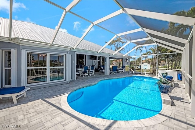 outdoor pool featuring glass enclosure and a patio area