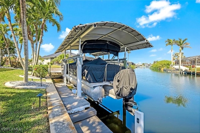 view of dock with a water view, boat lift, and a lawn