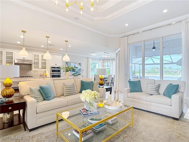 living room with a tray ceiling, ornamental molding, and recessed lighting