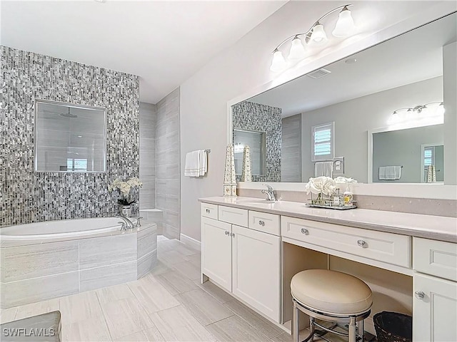 full bathroom featuring a tile shower, vanity, a garden tub, and visible vents