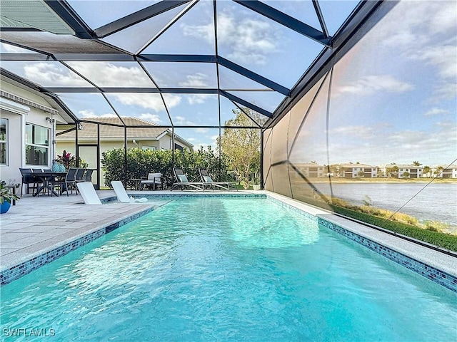 pool with a water view, a patio area, and glass enclosure